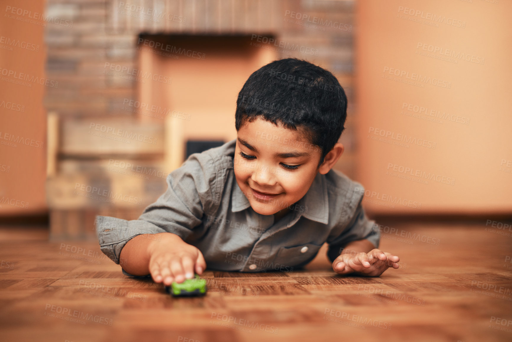Buy stock photo Shot of an adorable little boy playing with a toy car at home