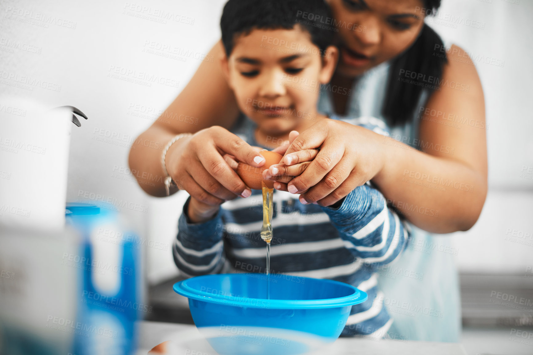 Buy stock photo Shot of a mother and her little son cracking an egg together while baking at home