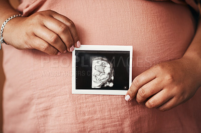 Buy stock photo Closeup shot of an unrecognisable woman holding a sonogram in front of her pregnant belly