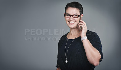 Buy stock photo Studio shot of a young businesswoman using a mobile phone against a grey background