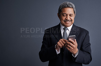 Buy stock photo Studio shot of a mature businessman using his cellphone
