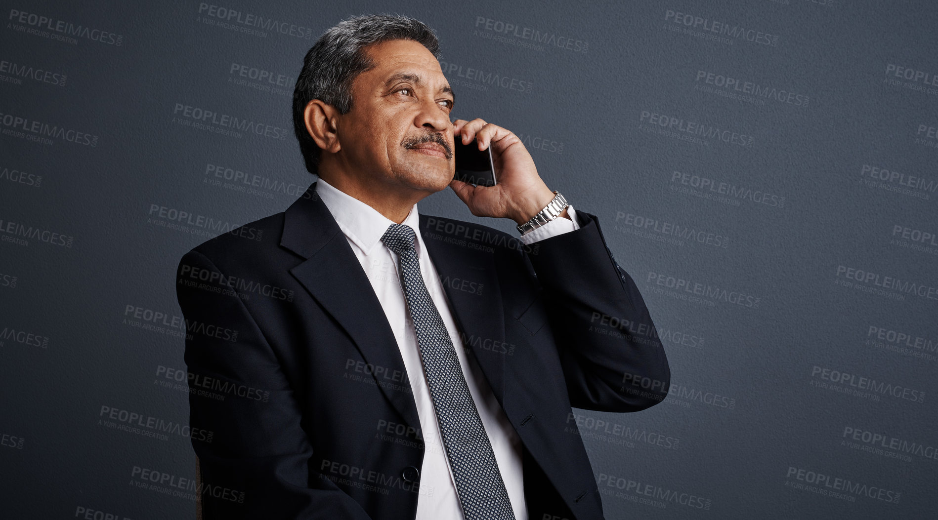 Buy stock photo Studio shot of a mature businessman talking on his cellphone