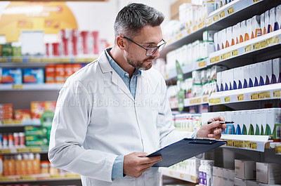 Buy stock photo Shot of a mature pharmacist doing inventory in a pharmacy