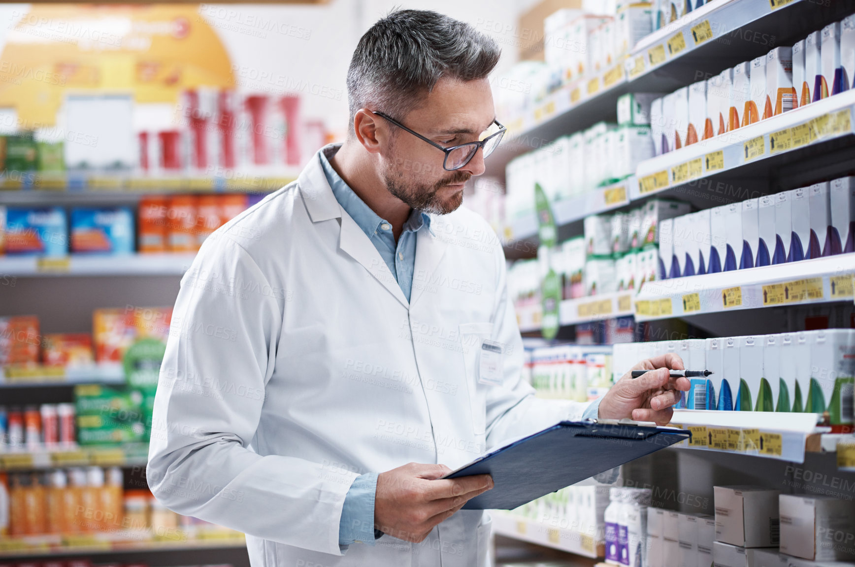 Buy stock photo Shot of a mature pharmacist doing inventory in a pharmacy