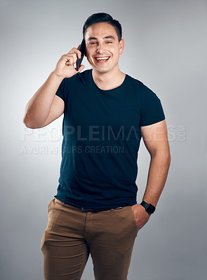 Buy stock photo Studio shot of a handsome young man on call against a grey background