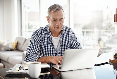 Buy stock photo Shot of a mature man working on a laptop at home