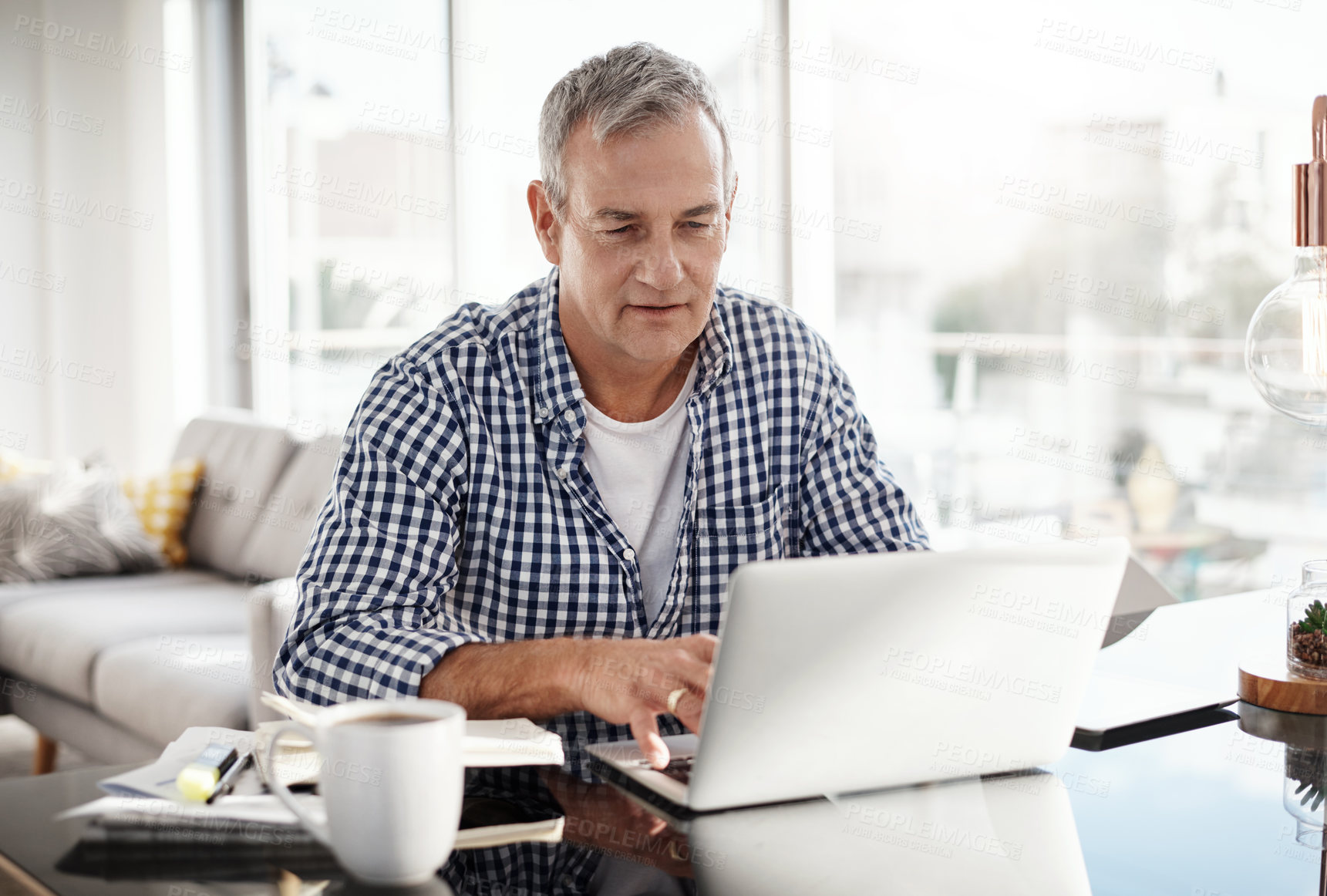 Buy stock photo Shot of a mature man working on a laptop at home