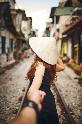 Buy stock photo Shot of a woman pulling her partner by the hand while exploring a foreign city