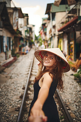 Buy stock photo Shot of a woman pulling her partner by the hand while exploring a foreign city
