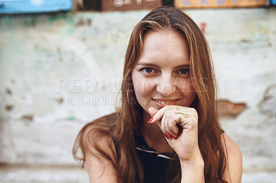 Buy stock photo Cropped shot of a young woman sitting outside while exploring a foreign city