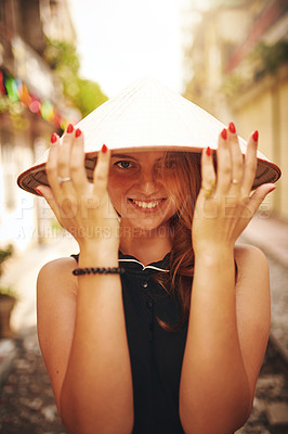 Buy stock photo Shot of a young woman wearing a conical hat while exploring a foreign city