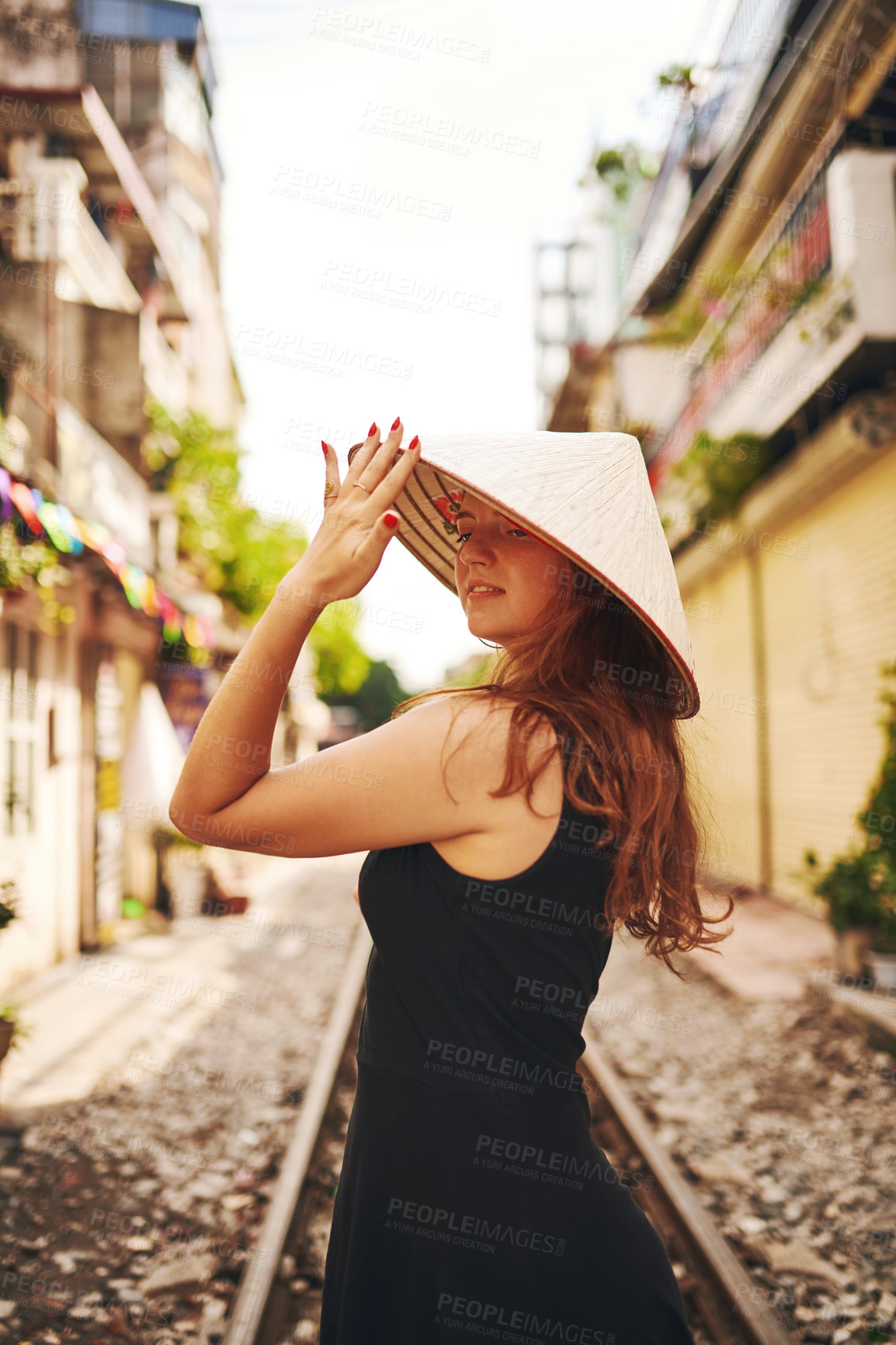 Buy stock photo Travel, fashion and woman on train track in city for holiday, vacation and tourist destination in Vietnam. Hat, sightseeing and person by railway for adventure, journey and explore urban market