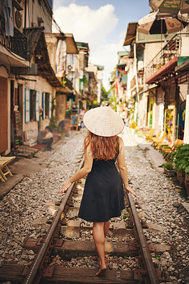 Buy stock photo Shot of a young woman wearing a conical hat while exploring a foreign city