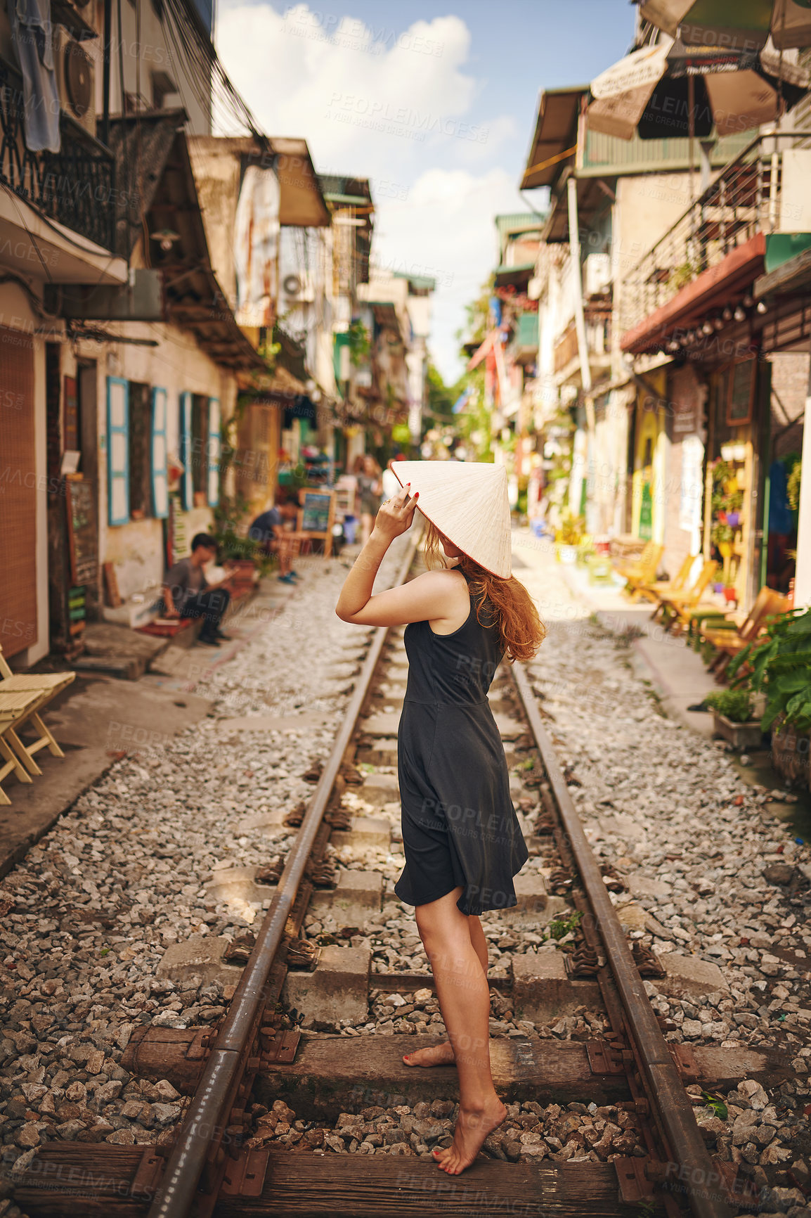 Buy stock photo Shot of a young woman wearing a conical hat while exploring a foreign city