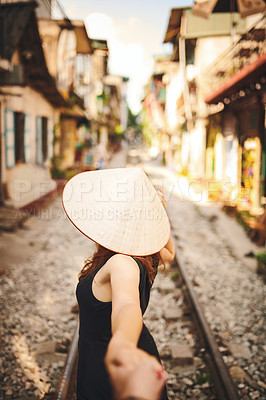 Buy stock photo Shot of a woman pulling her partner by the hand while exploring a foreign city