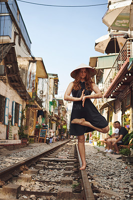Buy stock photo Shot of a woman practising yoga while out on the streets of Vietnam