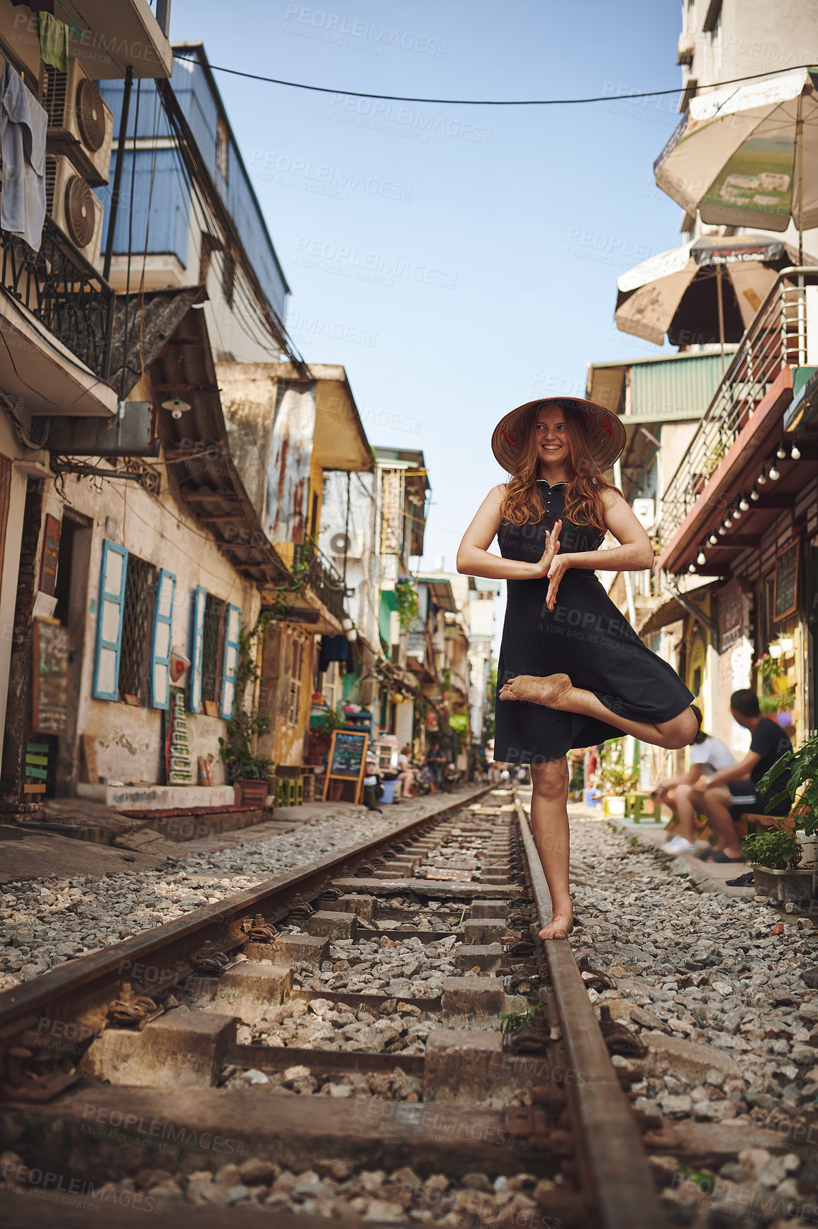 Buy stock photo Shot of a woman practising yoga while out on the streets of Vietnam