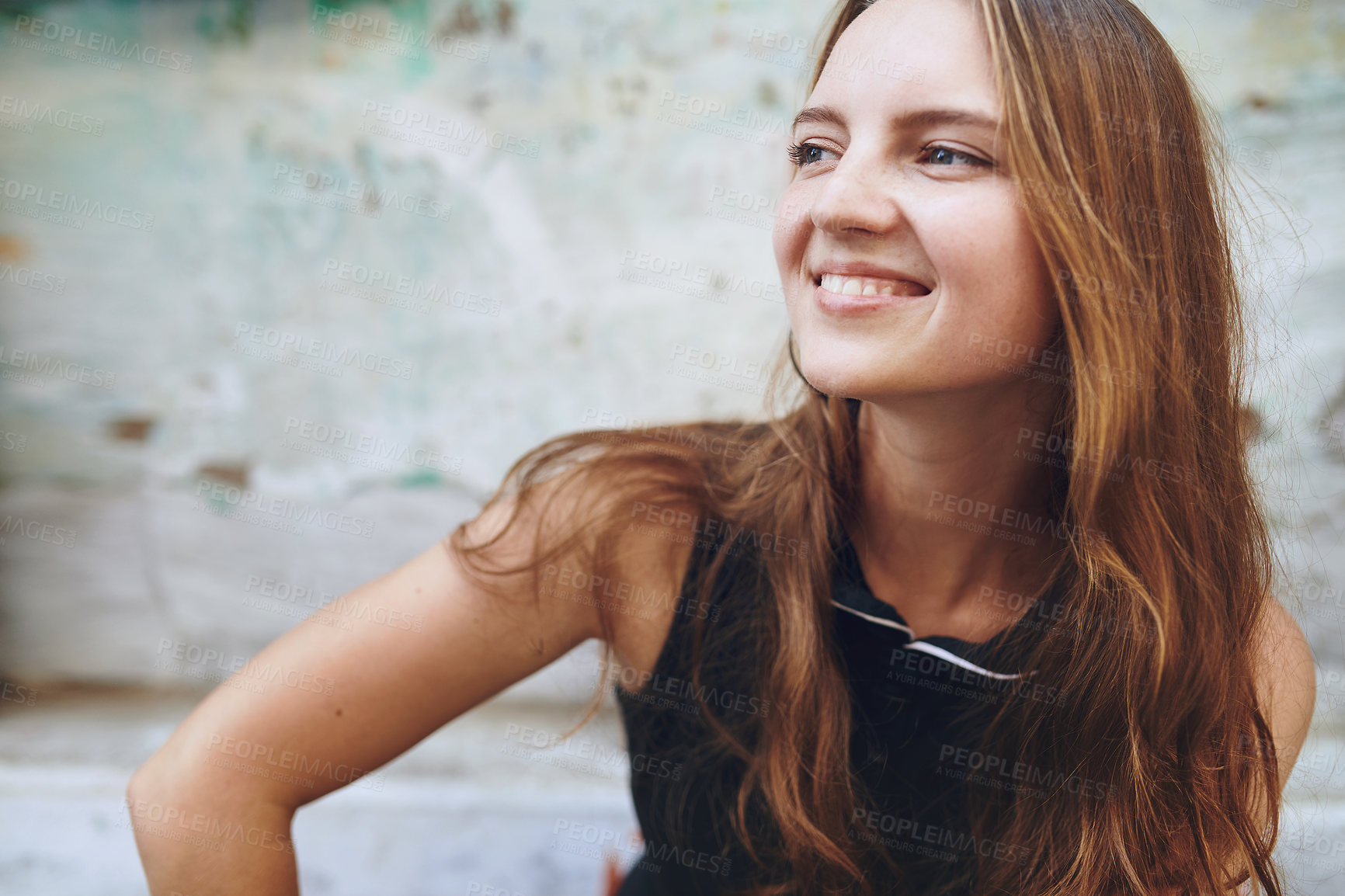 Buy stock photo Cropped shot of a young woman sitting outside while exploring a foreign city