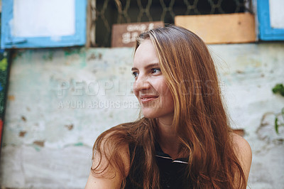 Buy stock photo Cropped shot of a young woman sitting outside while exploring a foreign city