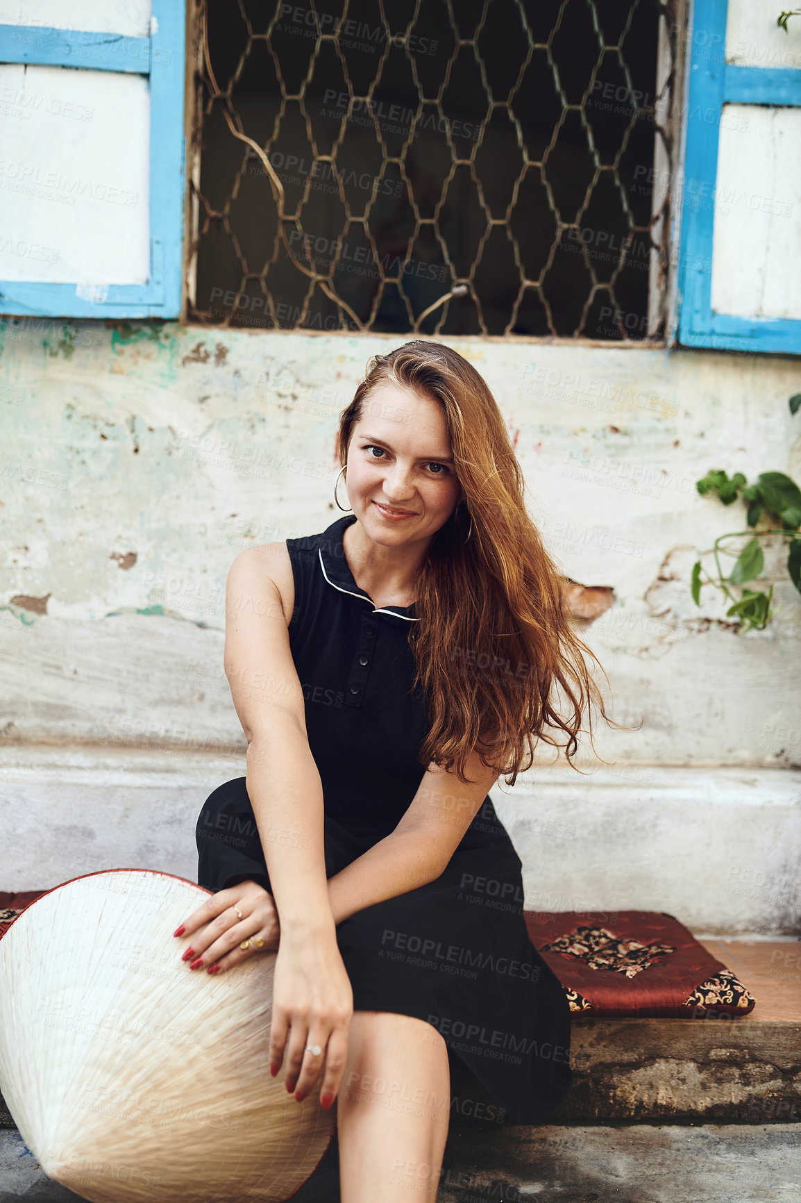 Buy stock photo Cropped shot of a young woman sitting outside while exploring a foreign city