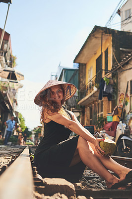 Buy stock photo City, railway and portrait of woman with drink for holiday, vacation and tourist destination in Vietnam. Happy, travel and person with coconut on train tracks for adventure, journey and local market