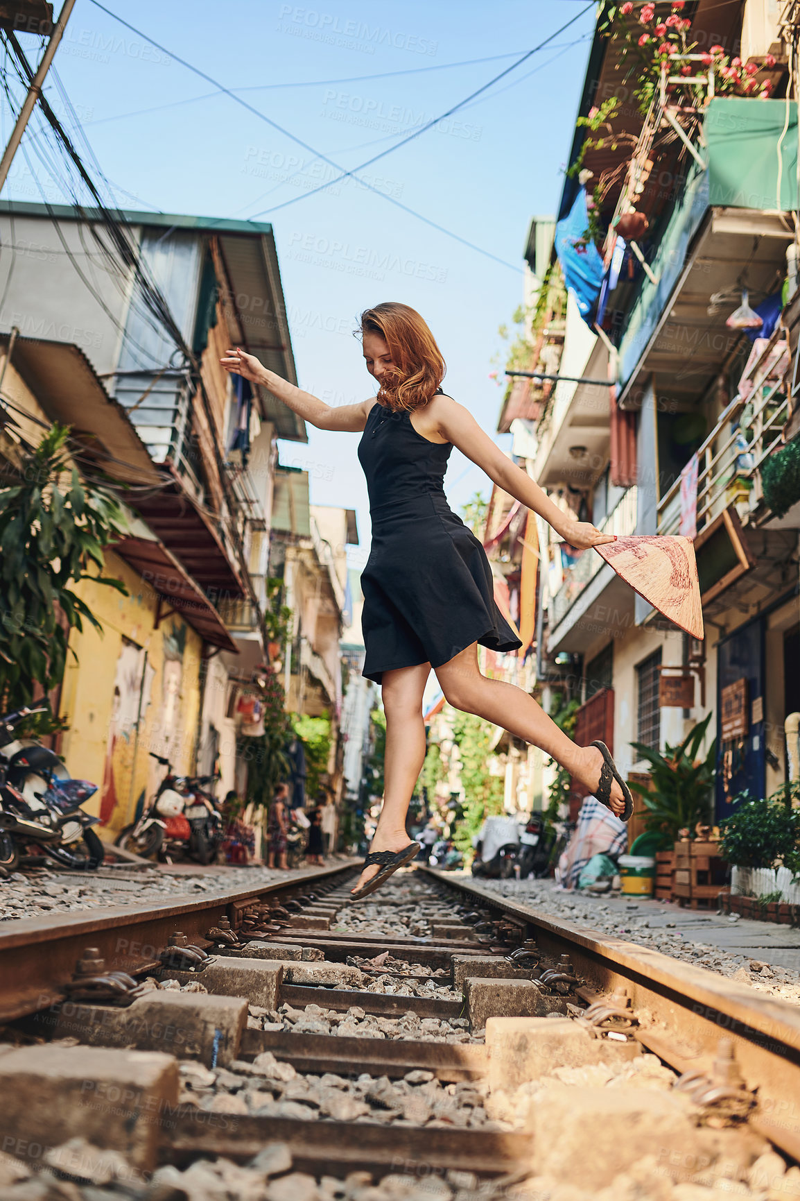 Buy stock photo Shot of a woman out on the train tracks in the streets of Vietnam