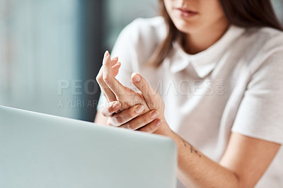 Buy stock photo Closeup shot of an unrecognisable businesswoman experiencing discomfort in her hand while working in an office
