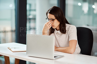 Buy stock photo Shot of a young businesswoman looking stressed out while working in an office