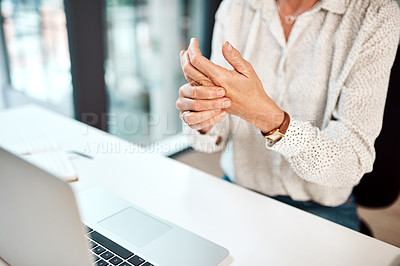 Buy stock photo Closeup shot of an unrecognisable businesswoman experiencing discomfort in her hand while working in an office