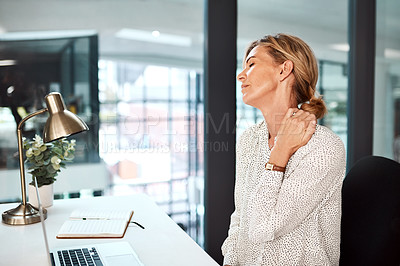 Buy stock photo Shot of a mature businesswoman experiencing neck pain while working in an office