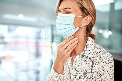 Buy stock photo Shot of a mature businesswoman wearing a mask and rubbing her throat in an office