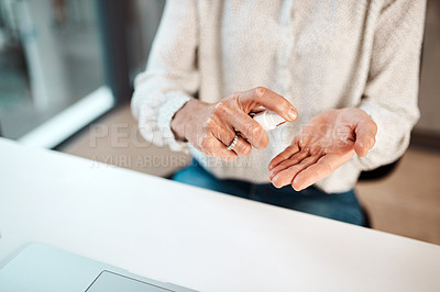 Buy stock photo Closeup shot of an unrecognisable businesswoman using hand sanitiser in an office