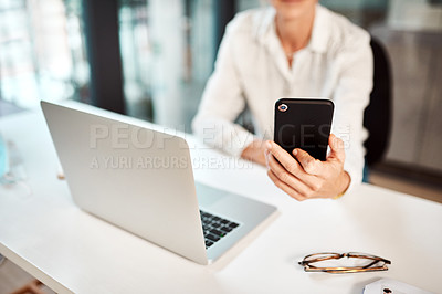 Buy stock photo Closeup shot of an unrecognisable businesswoman using a cellphone and laptop in an office