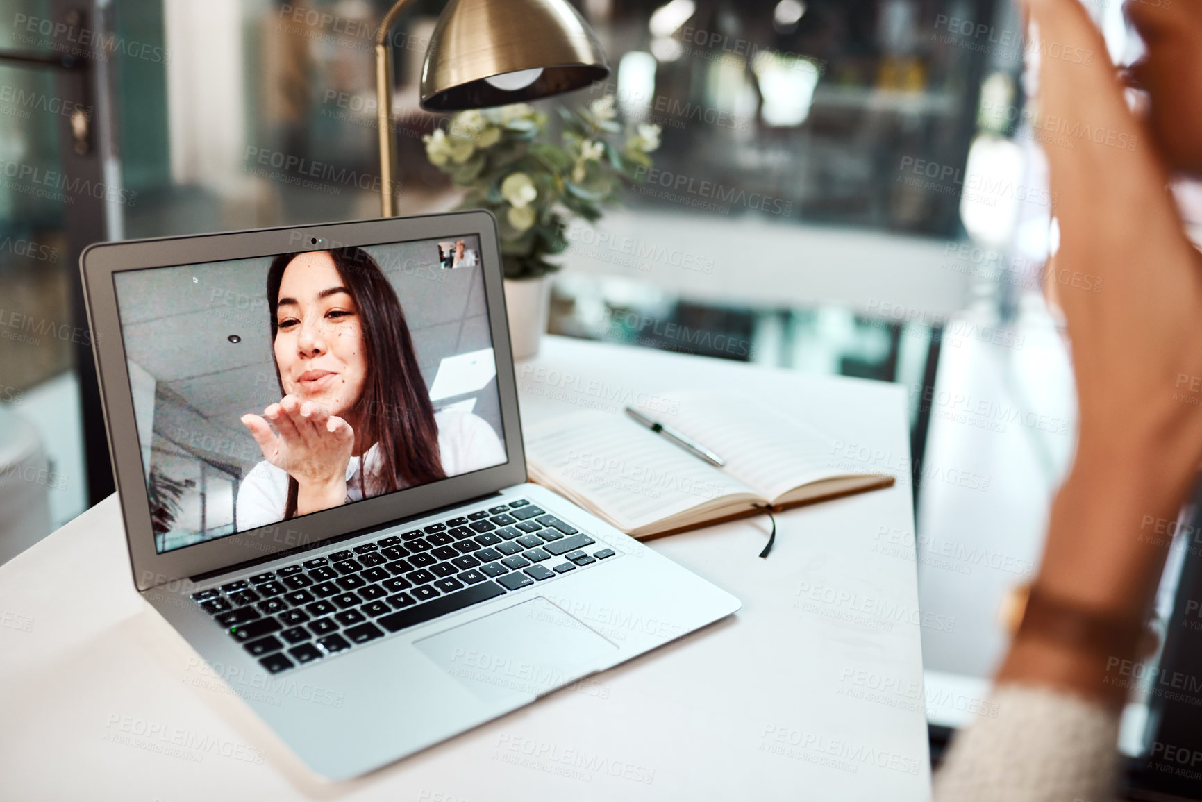 Buy stock photo Shot of a young woman blowing a kiss while appearing on a laptop screen during a video call