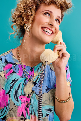 Buy stock photo Studio shot of a young woman holding a telephone while wearing 80s clothing