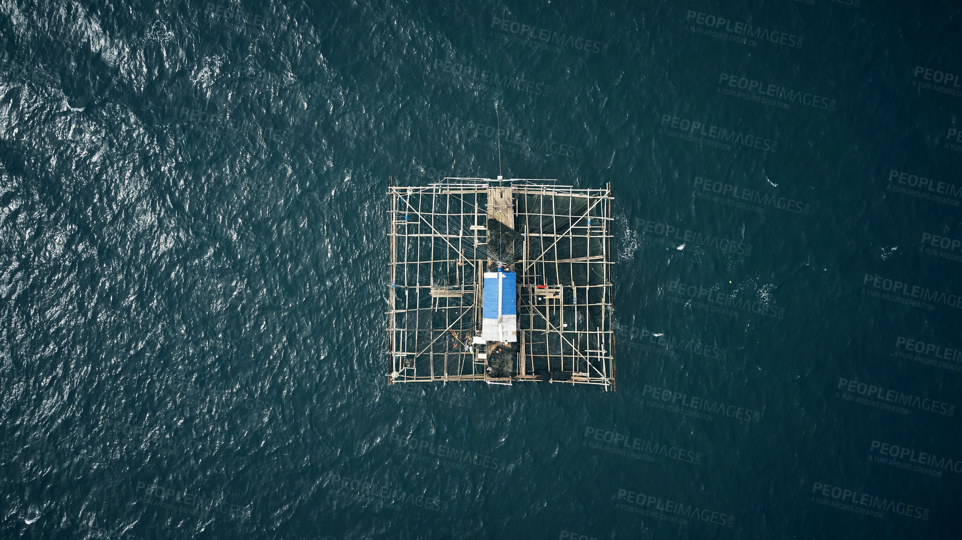 Buy stock photo High angle shot of a built fishing structure floating in the middle of the ocean called a kelong