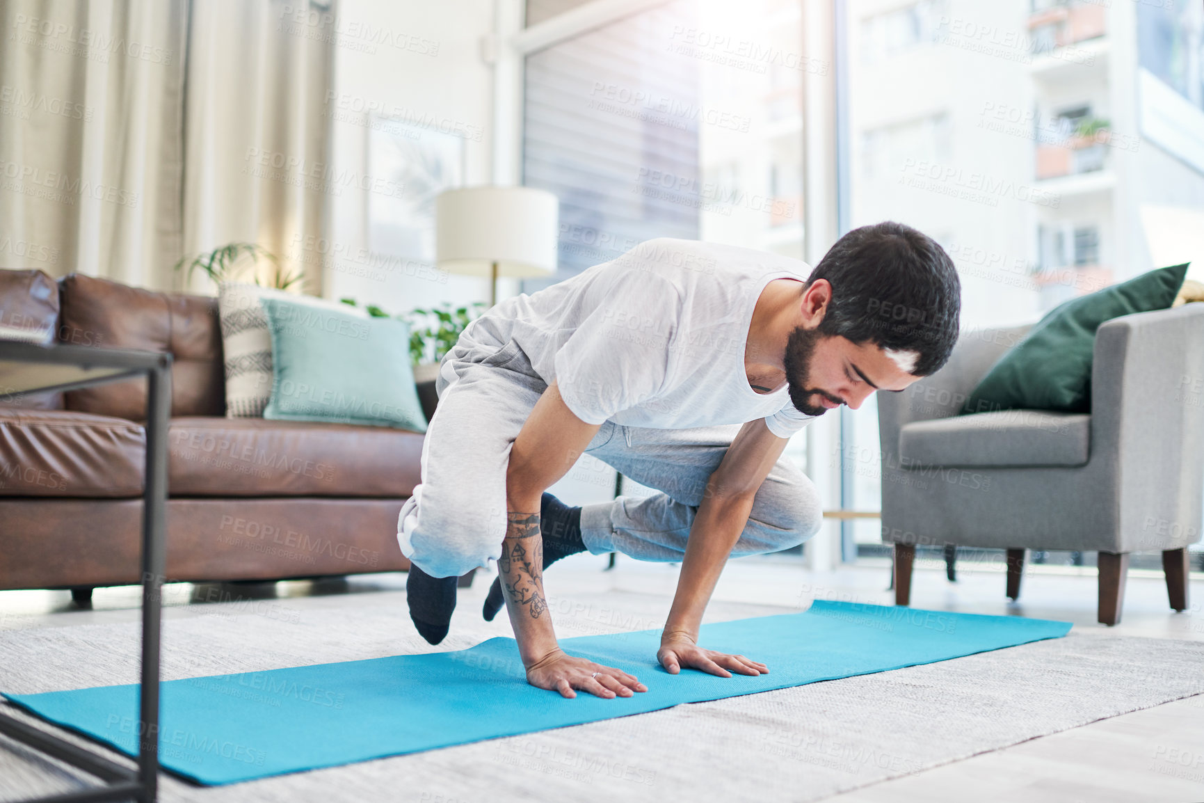 Buy stock photo Balance, crow pose and man with yoga in home for flexibility, mindfulness and wellness exercise. Challenge, fitness and male person with kakasana position for pilates workout in living room at house.