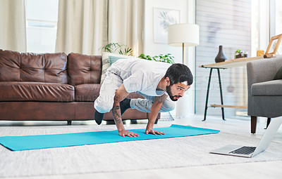 Buy stock photo Shot of a man using his laptop while practising yoga at home