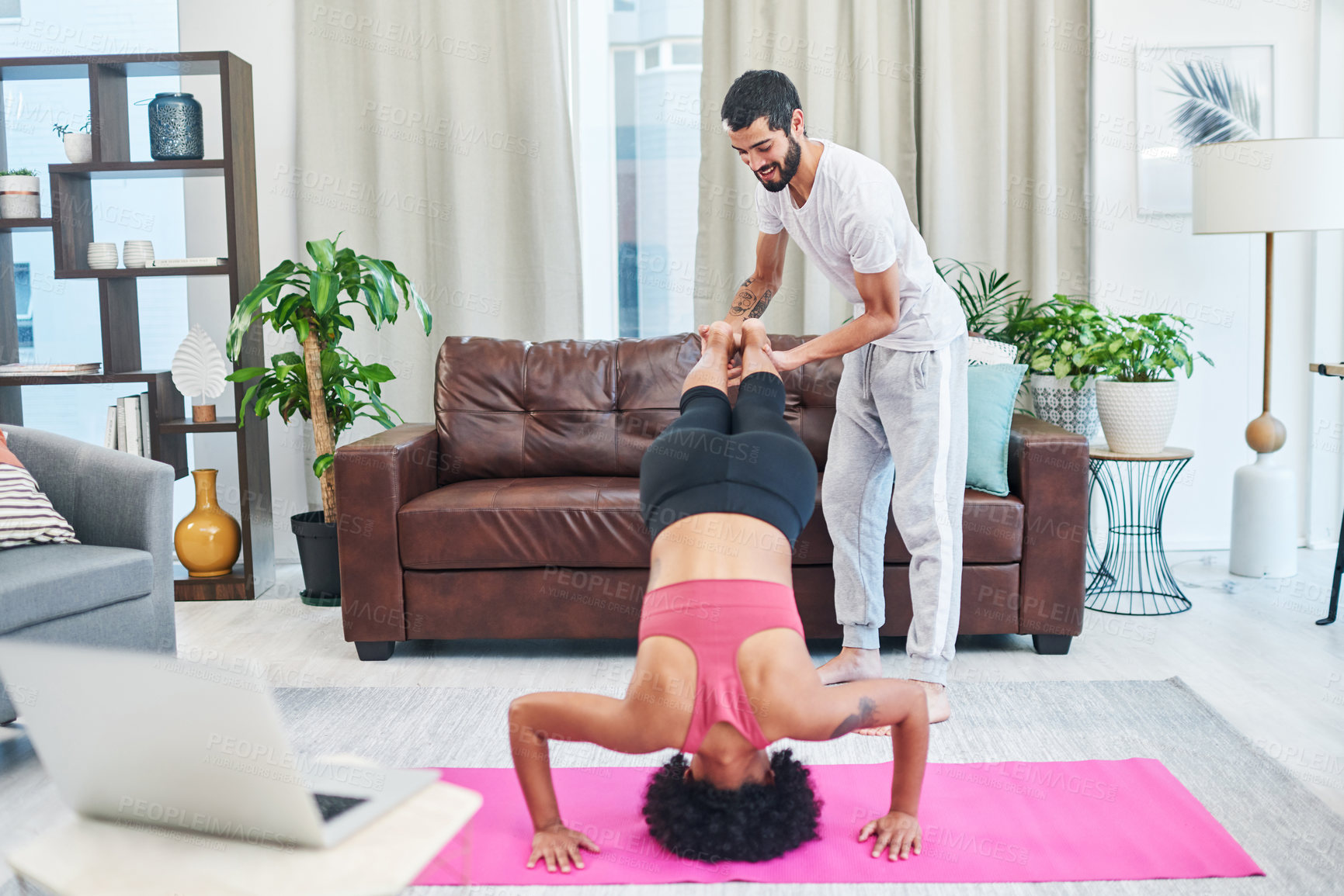 Buy stock photo Shot of a young couple practising yoga in their living room