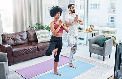 Buy stock photo Shot of a couple looking at the television while practising yoga at home