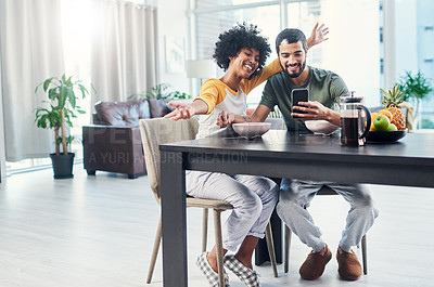 Buy stock photo Shot of a young couple taking a selfie while having breakfast at home