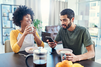 Buy stock photo Happy, interracial couple and breakfast with phone for morning, social media or agenda at home. Young, man and woman with smile on mobile smartphone for healthy snack, meal or tips on diet at house