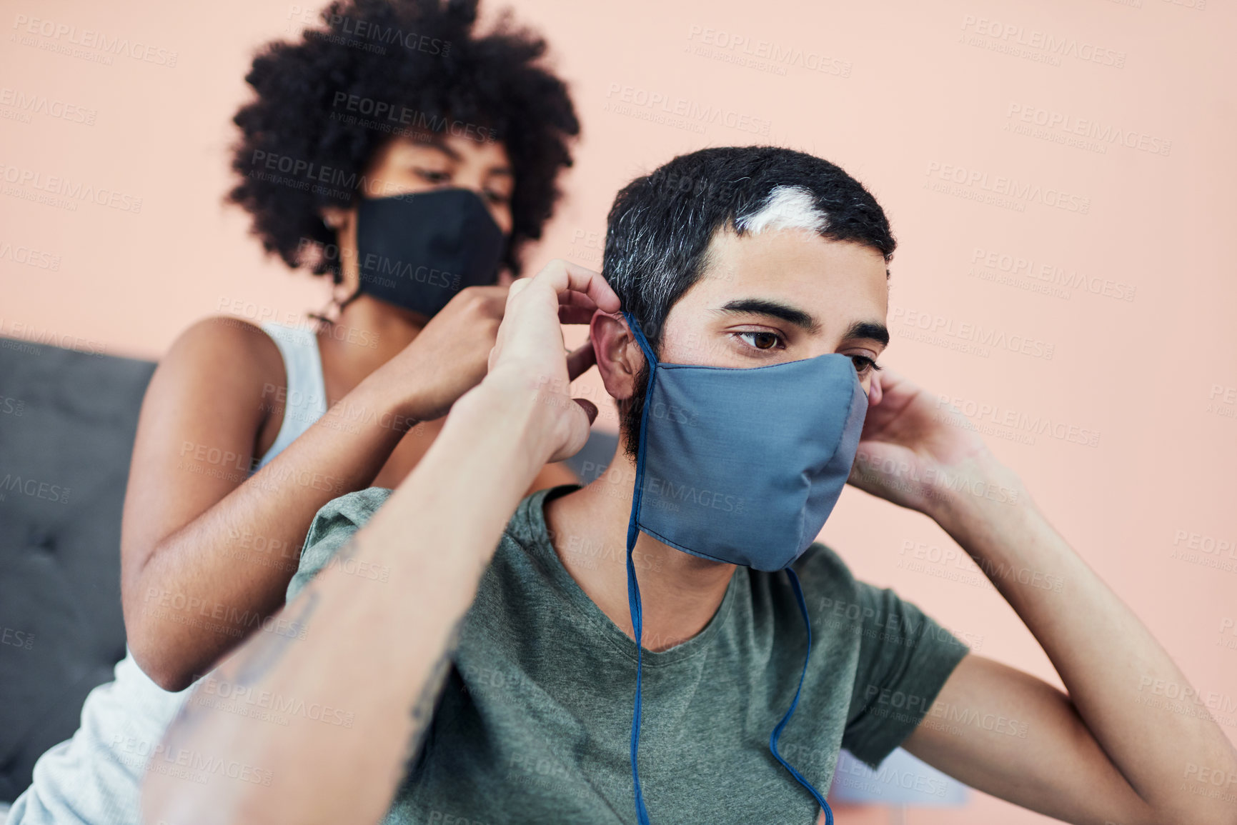Buy stock photo Cropped shot of a woman helping her boyfriend with his mask