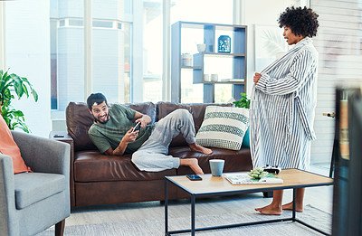 Buy stock photo Shot of a woman trying to get her boyfriend's attention while he plays video games