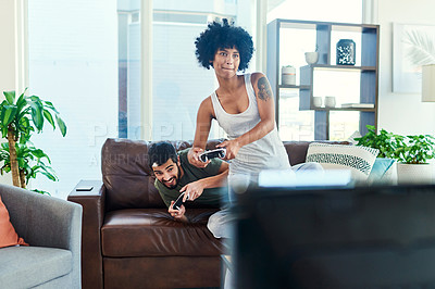 Buy stock photo Shot of a young couple having fun while playing video games at home