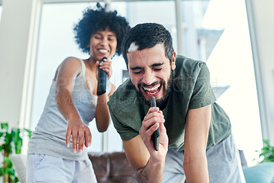 Buy stock photo Cropped shot of a couple having a sing along at home