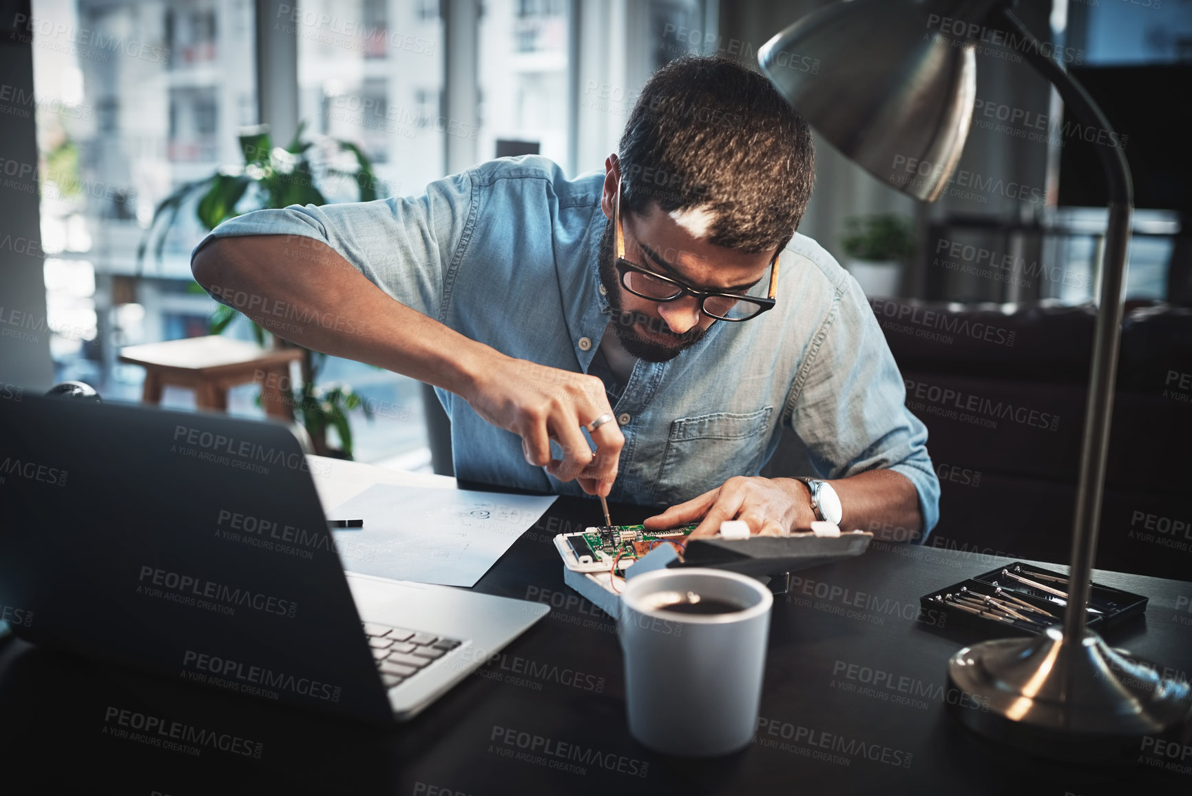 Buy stock photo Cropped shot of a young engineer working from home