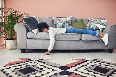 Buy stock photo Shot of a woman looking bored while lying on the sofa at home