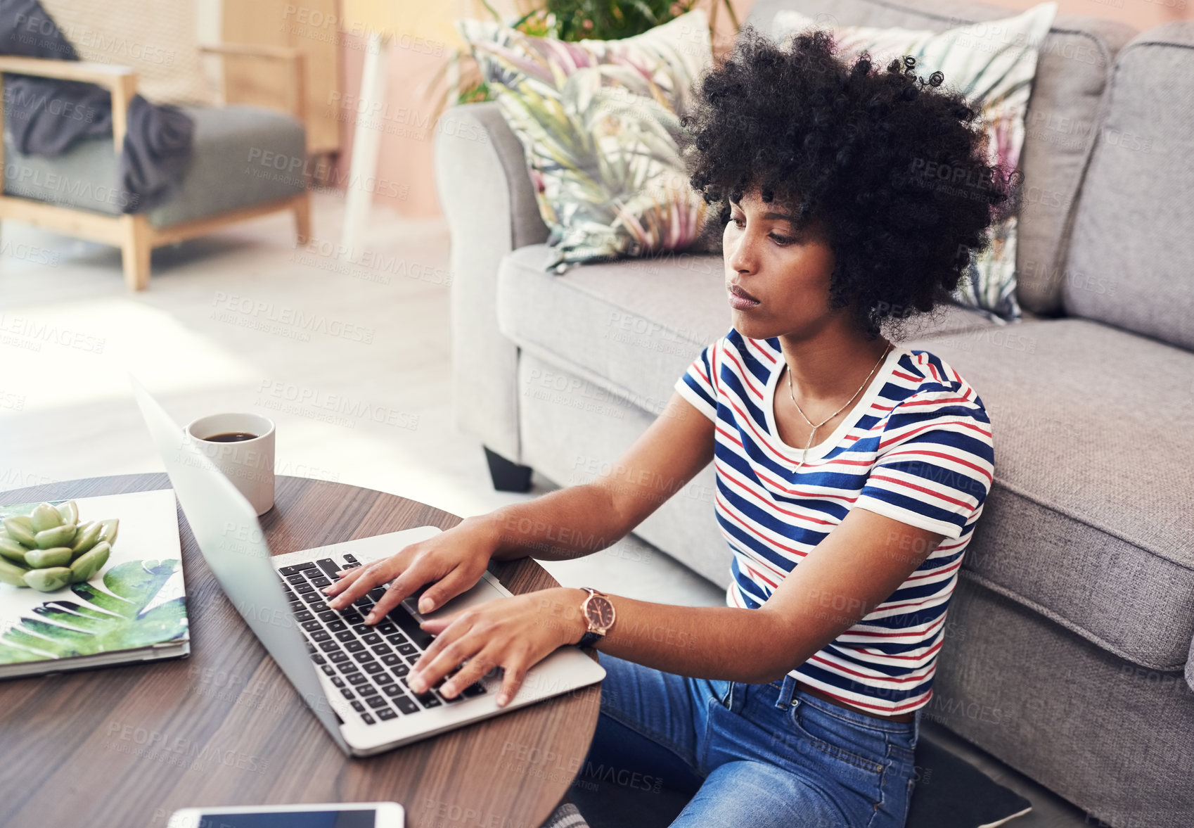 Buy stock photo Shot of a young woman using her laptop while sitting at home