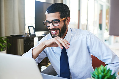 Buy stock photo Shot of a young man using his laptop while working from home